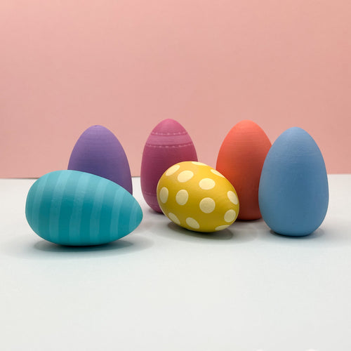Colorful Easter eggs on a white surface with a pink background