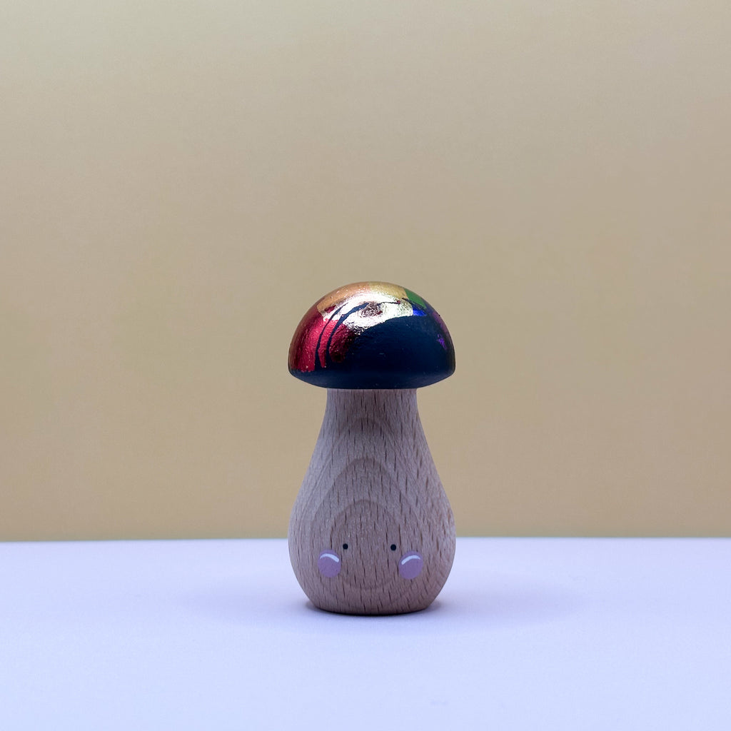 Wooden toy mushroom with a colorful cap on a beige background