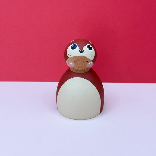 Wooden doll dressed as a squirrel on a red background