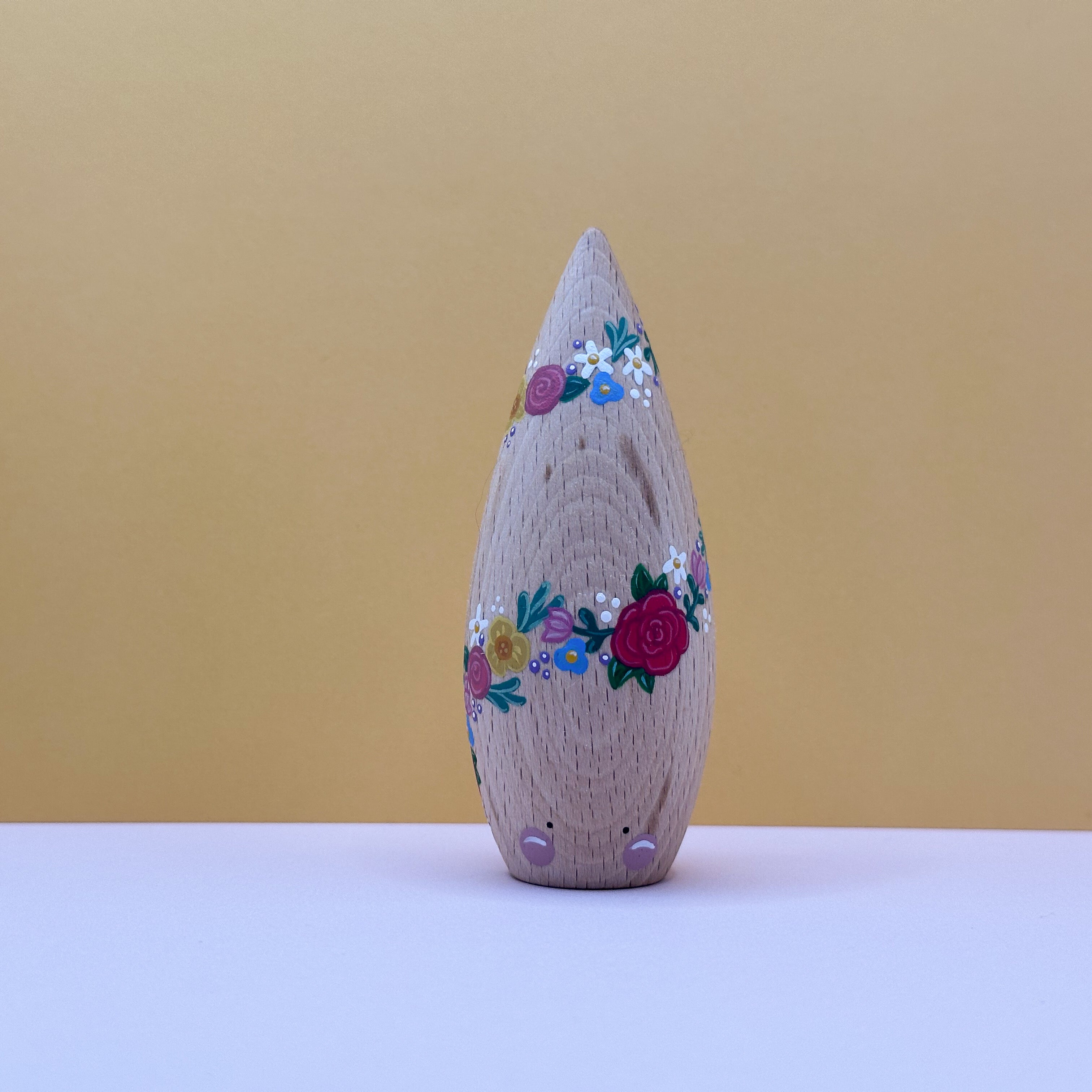 Decorative wooden toy with floral patterns on a beige background