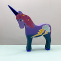 Colorful unicorn figurine with lightning bolt and cloud design on a plain background