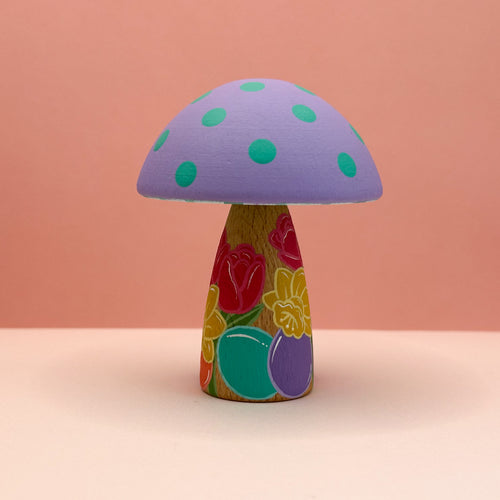 Colorful mushroom-shaped object with floral design on a pink background