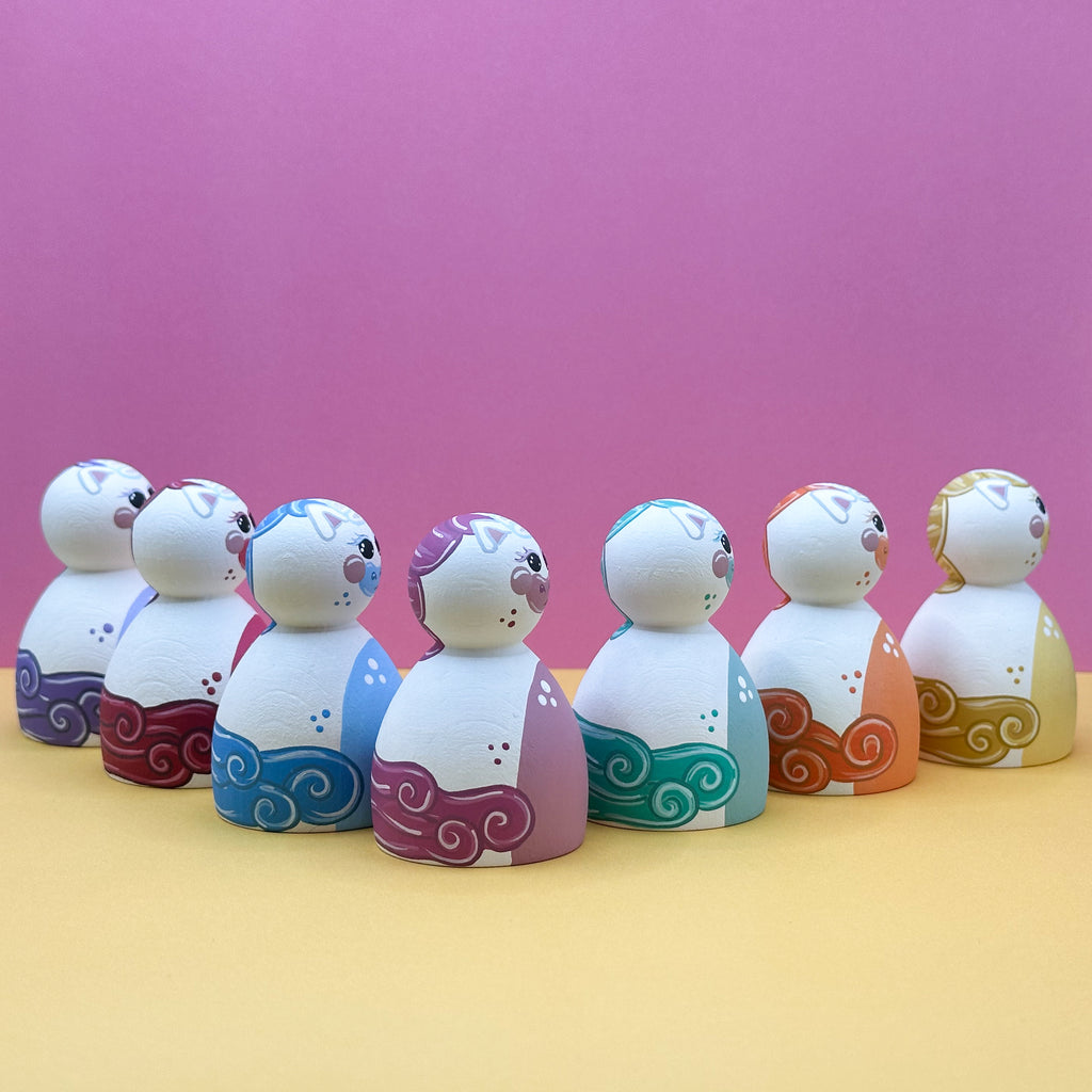 Set of colorful dolls with decorative patterns on a pink and yellow gradient background