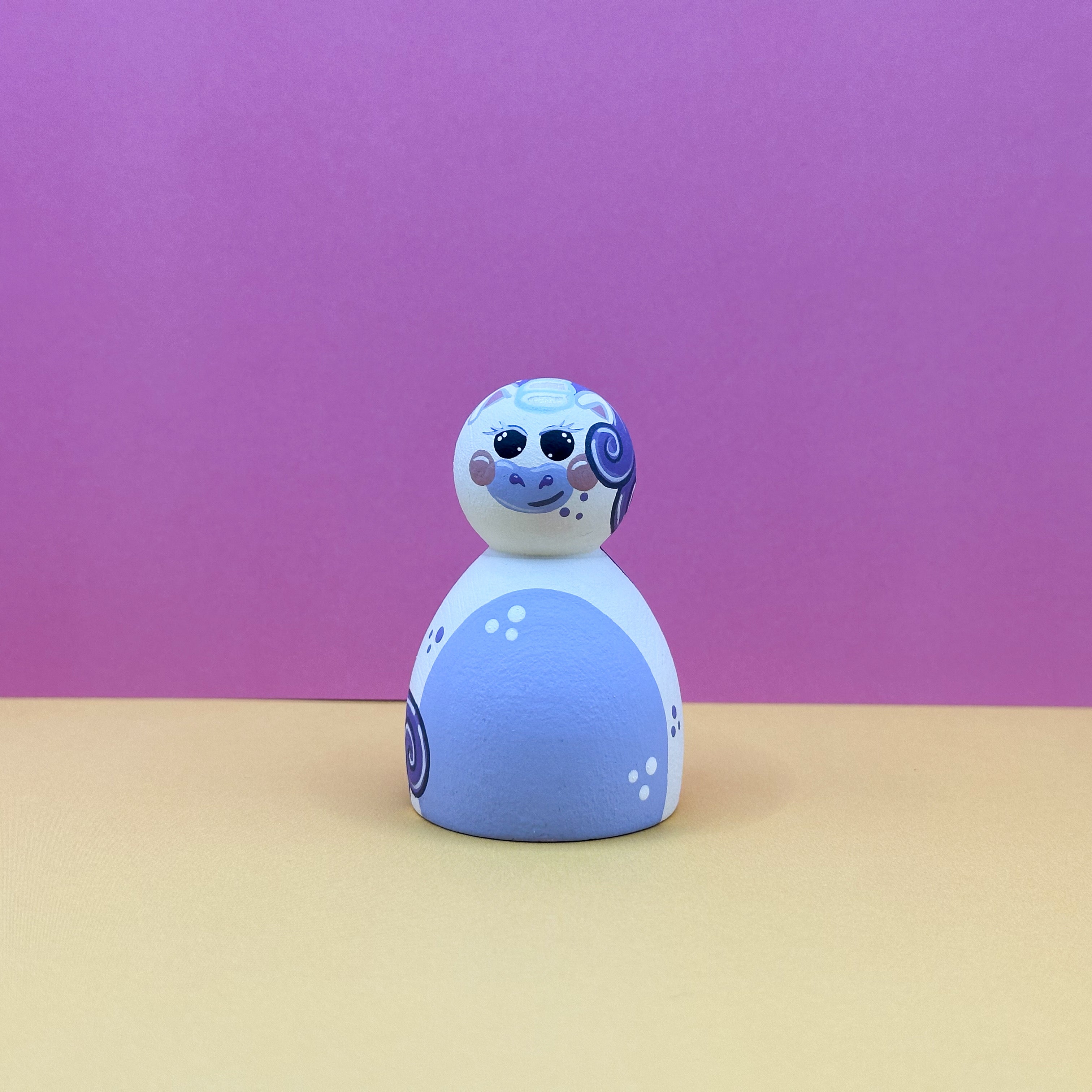 purple and white toy figure with a pink background