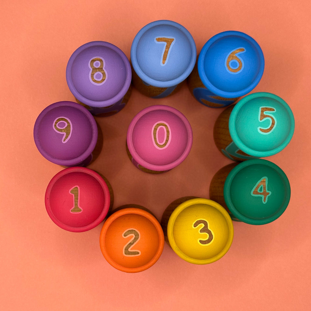 Colorful number doll hats arranged in a circle on an orange background