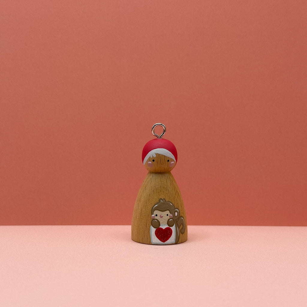 Small peg doll keyring with a Monkey holding a heart sign painted on its body with a peach background