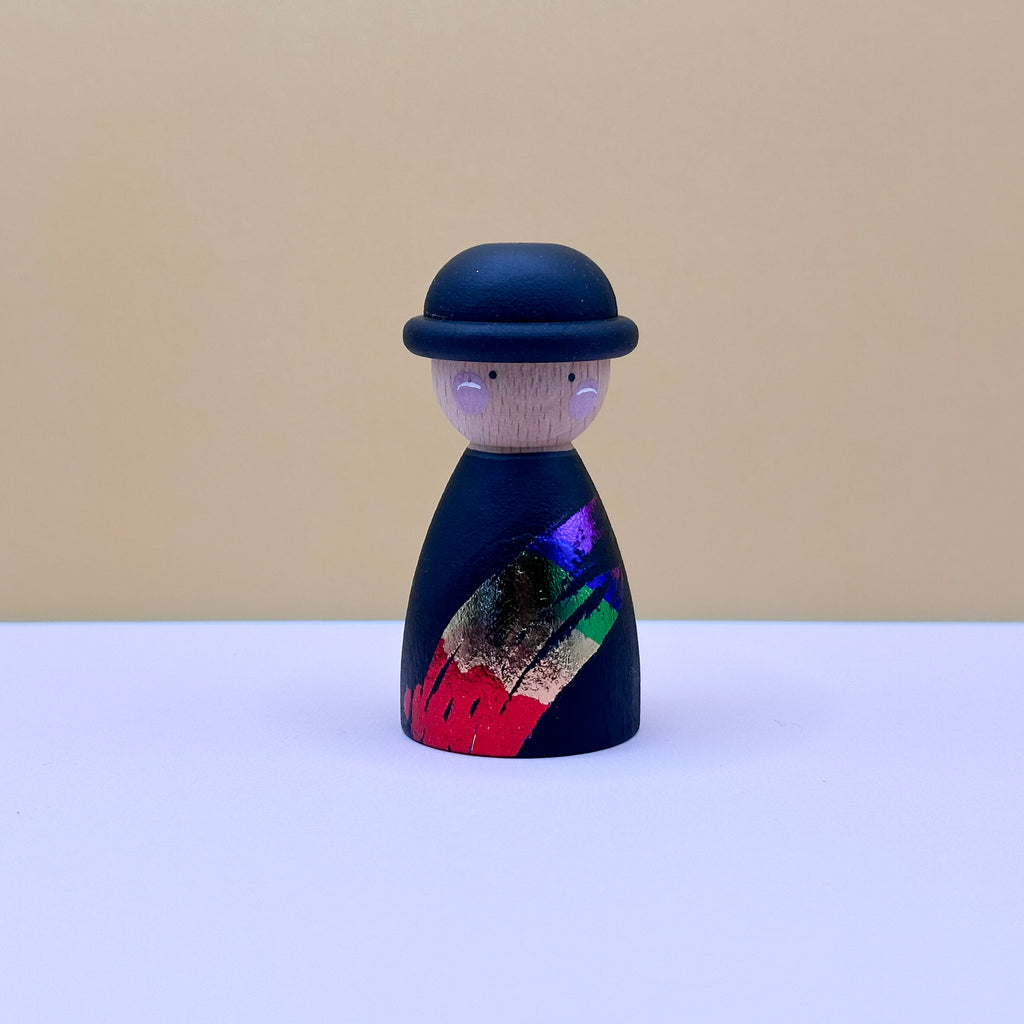 Wooden peg doll with a colorful design on a beige background