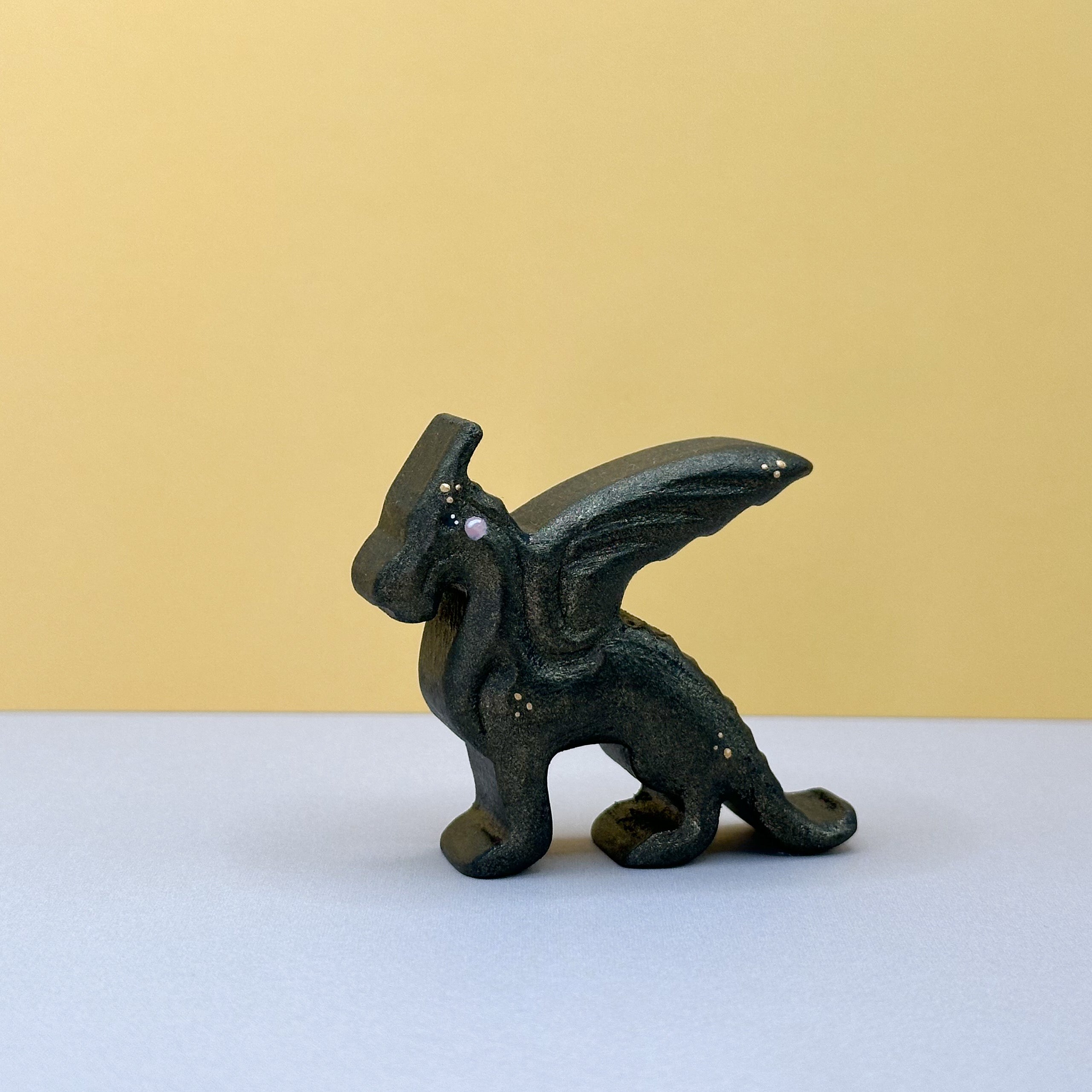 A small wooden black dragon on a yellow background