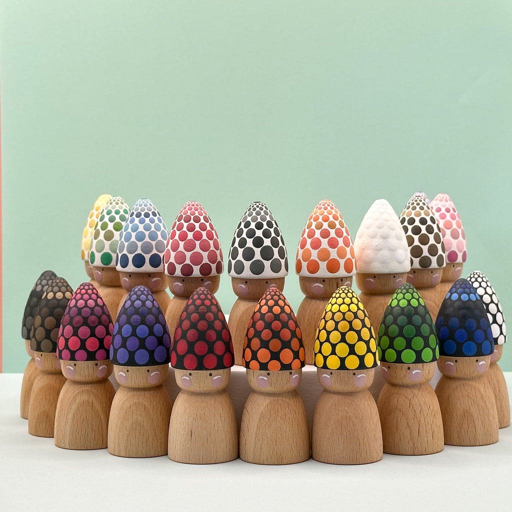Set of wooden peg dolls with colorful, patterned hats on a light green background