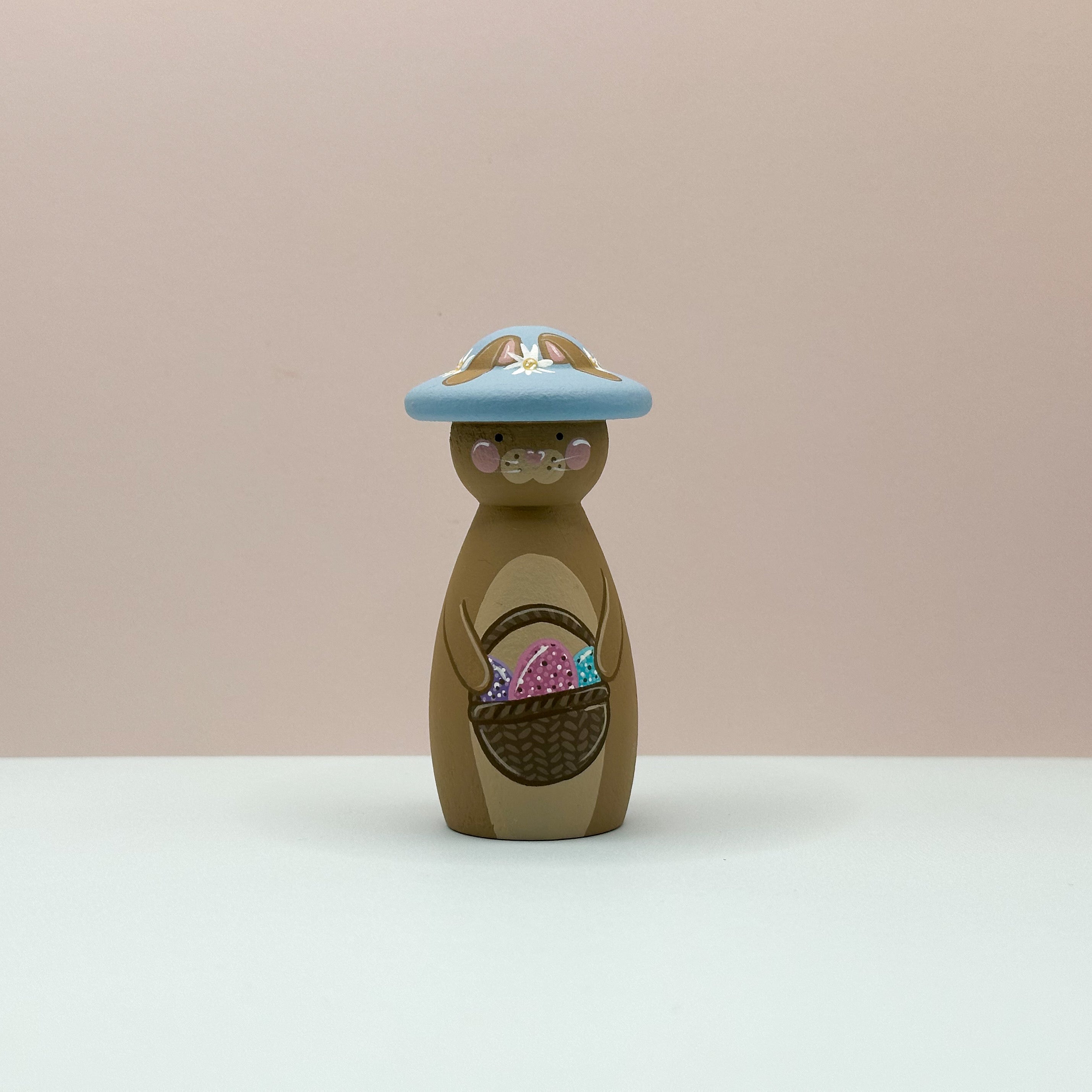 Wooden Bunny with an Easter hat on a beige background