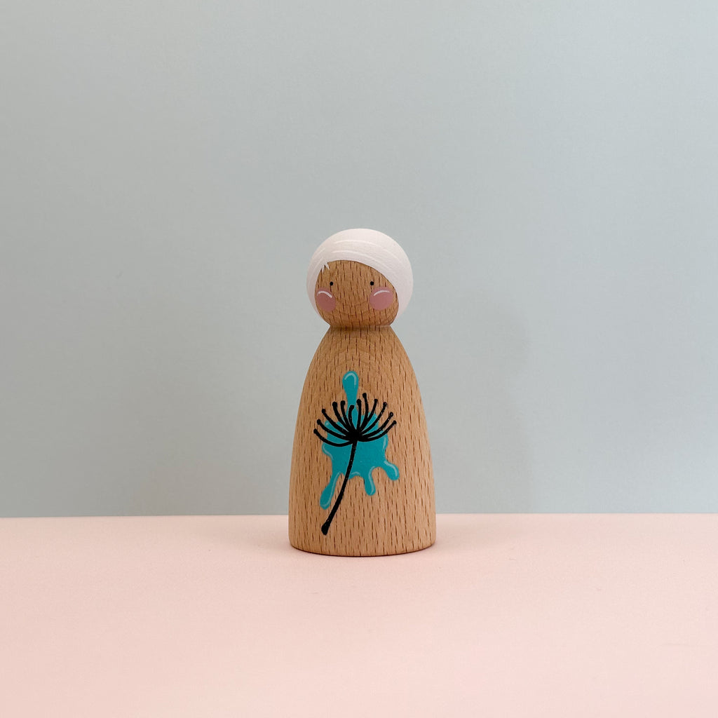 Wooden peg doll with a blue dandelion design on a light gray background