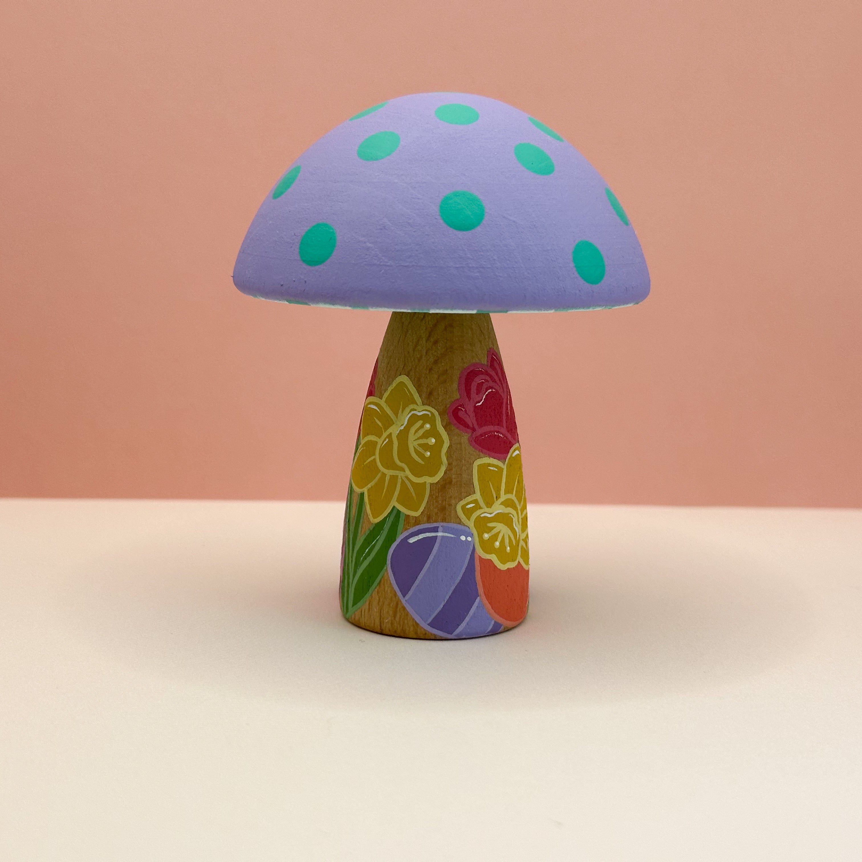 Colorful mushroom-shaped object with a patterned stem on a beige background