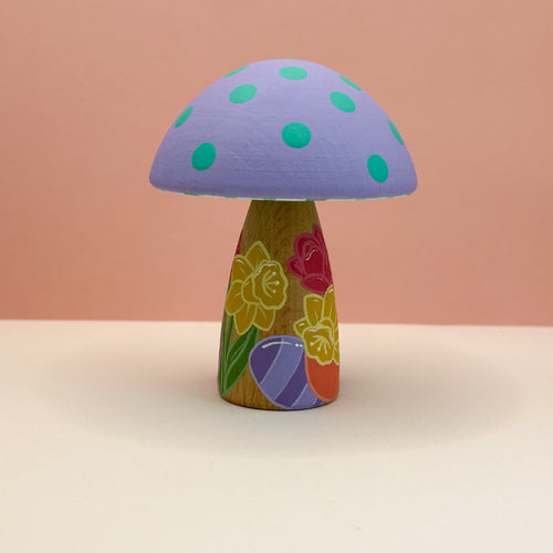 Colorful mushroom-shaped object with a patterned stem on a beige background
