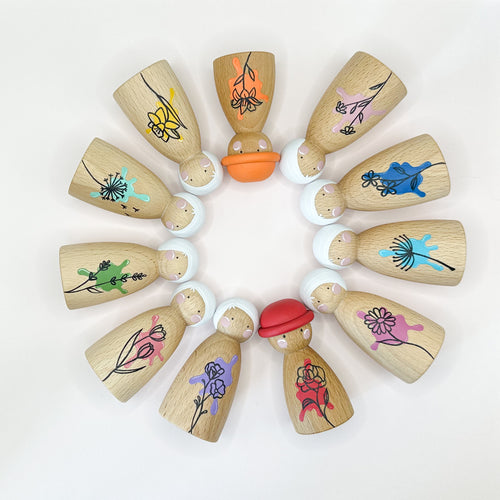 Wooden peg dolls with colorful hand-drawn designs on a white background