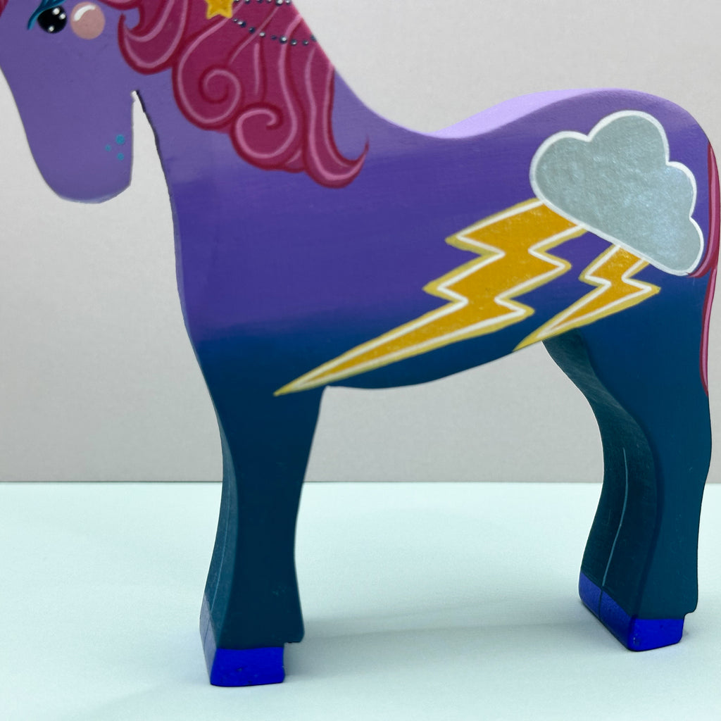 Colorful unicorn figurine with purple body, blue legs, and pink mane on a white background