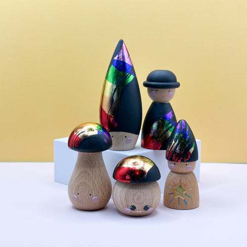 Wooden mushroom figurines with colorful caps on a white surface against a yellow background
