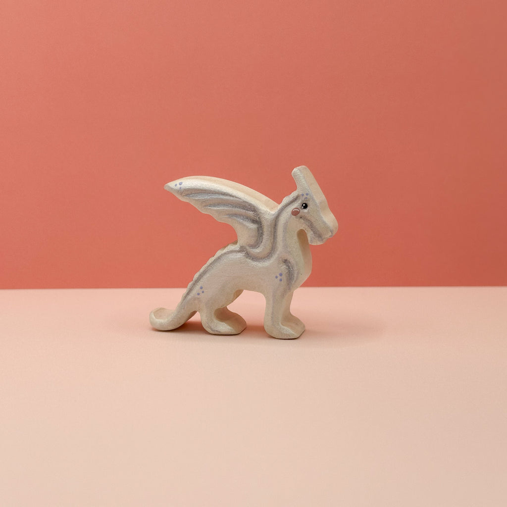 A small wooden black dragon on a peach background
