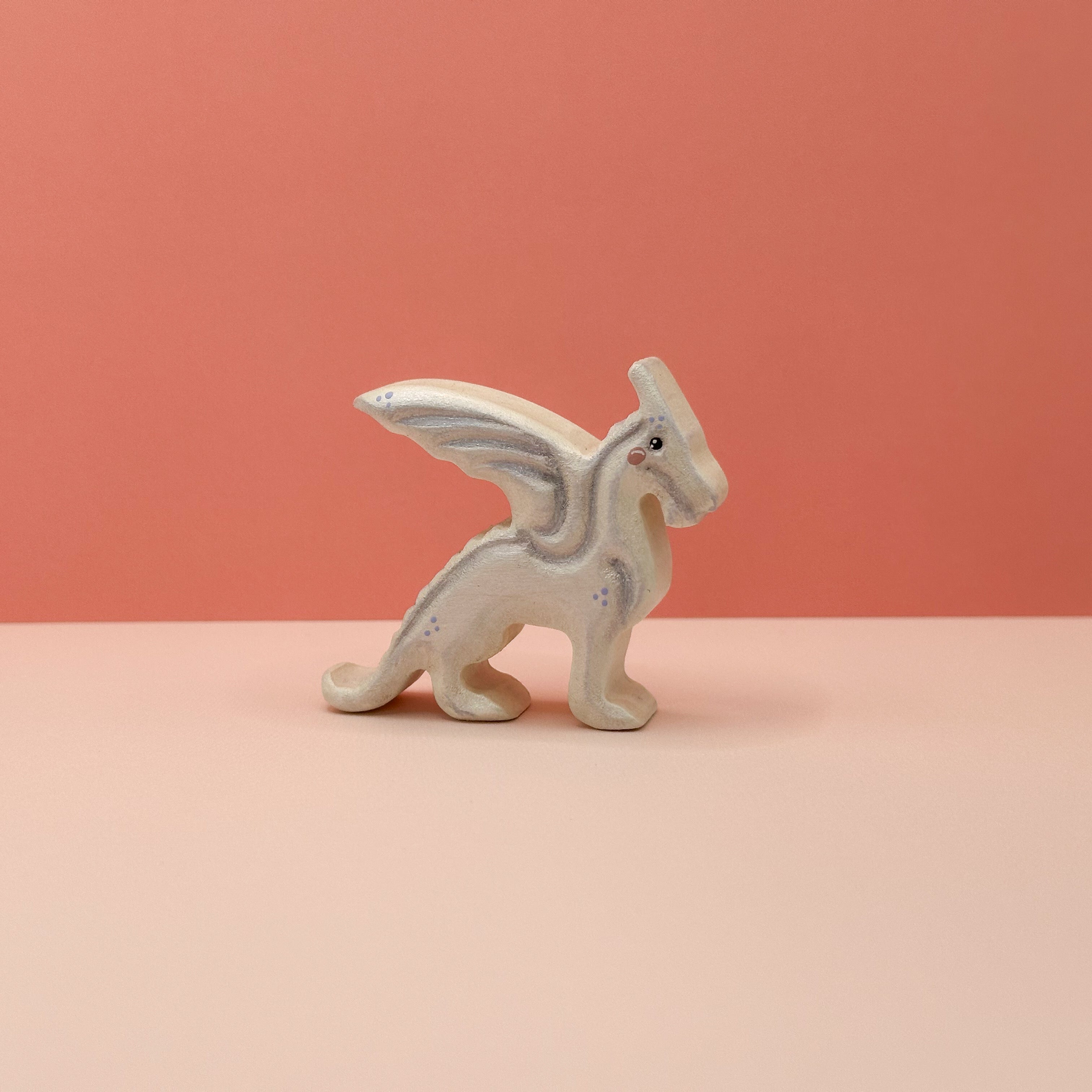 A small wooden black dragon on a peach background