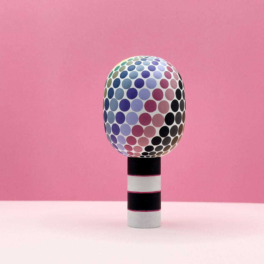 Colorful polka dot object on a pink background