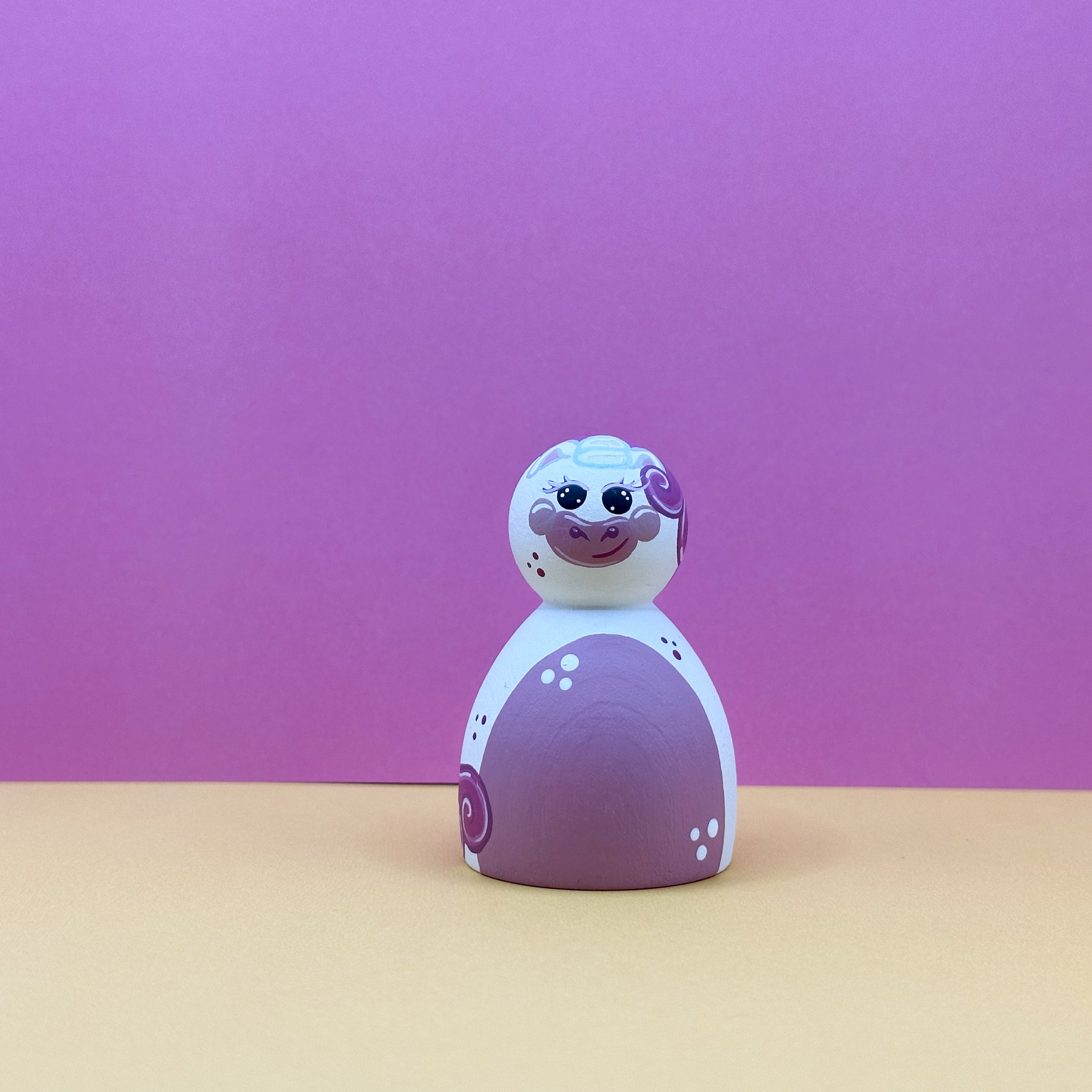 Toy figure with a pink and white design on a pink background