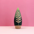 Wooden toy with leaf design on a pink background