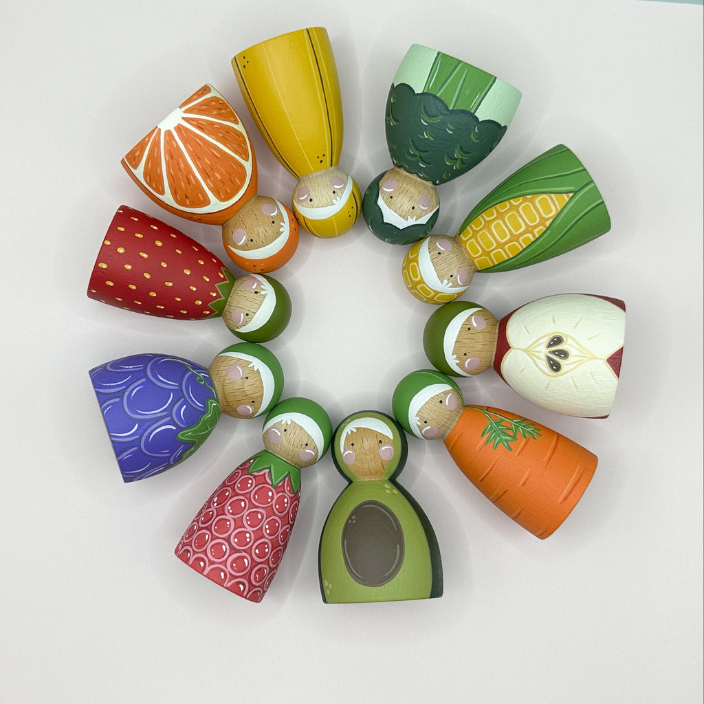 Colorful toy fruits and vegetables arranged in a circular pattern on a white background