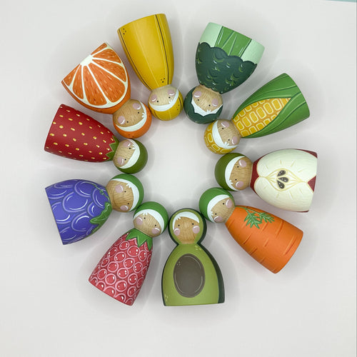Colorful toy fruits and vegetables arranged in a circular pattern on a white background