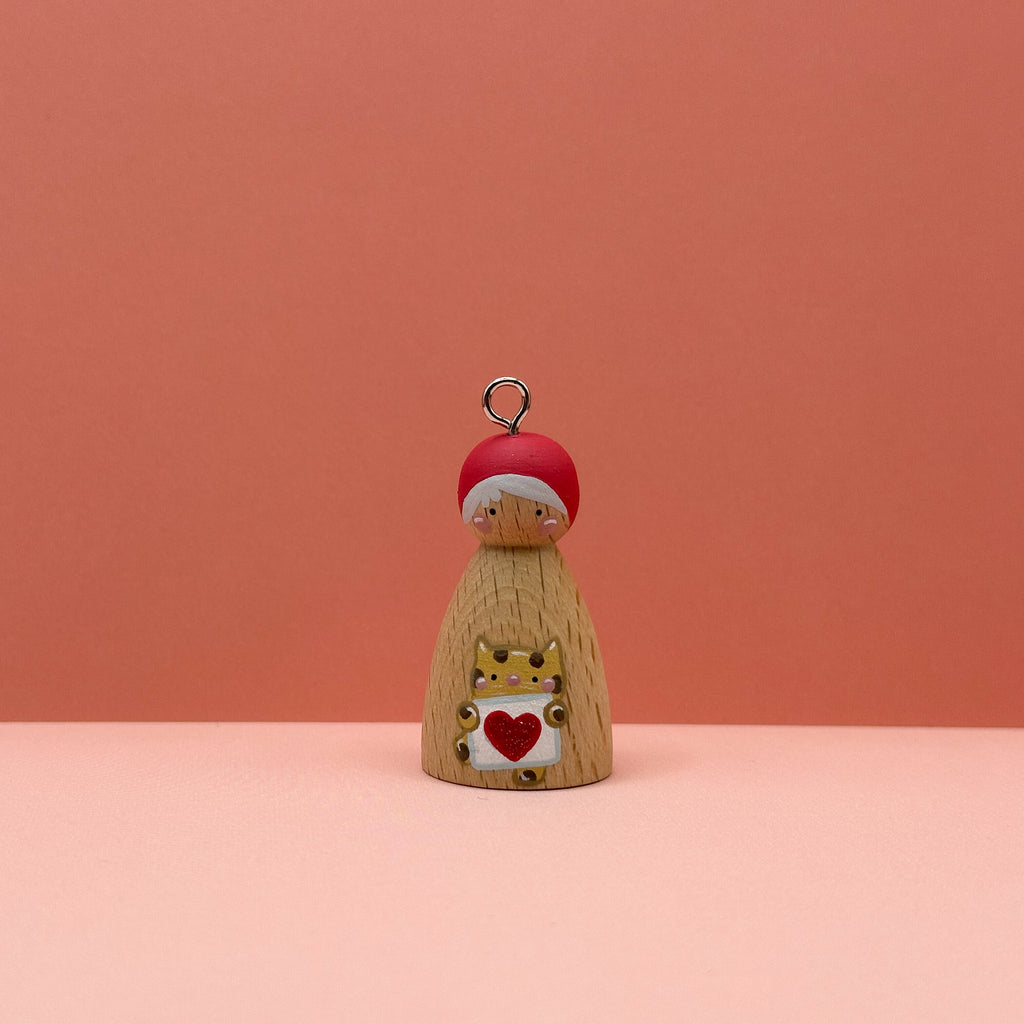 Small peg doll keyring with a cheetah holding a heart sign painted on its body with a peach background