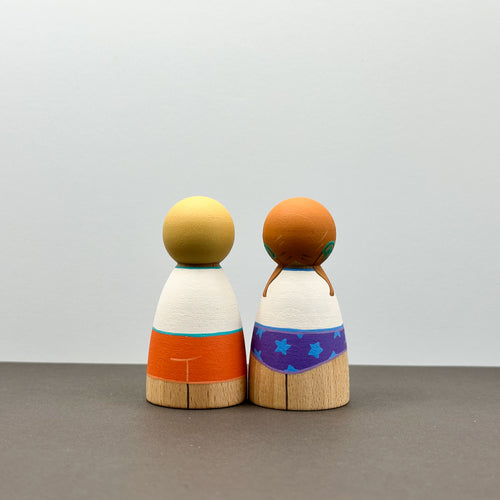 Two wooden peg dolls wearing sun safe swimwear
