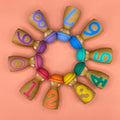 Colorful wooden number toys arranged in a circular pattern on a peach background