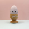 Decorative egg with a wooden stand and 'You're a good egg' text on a pink background