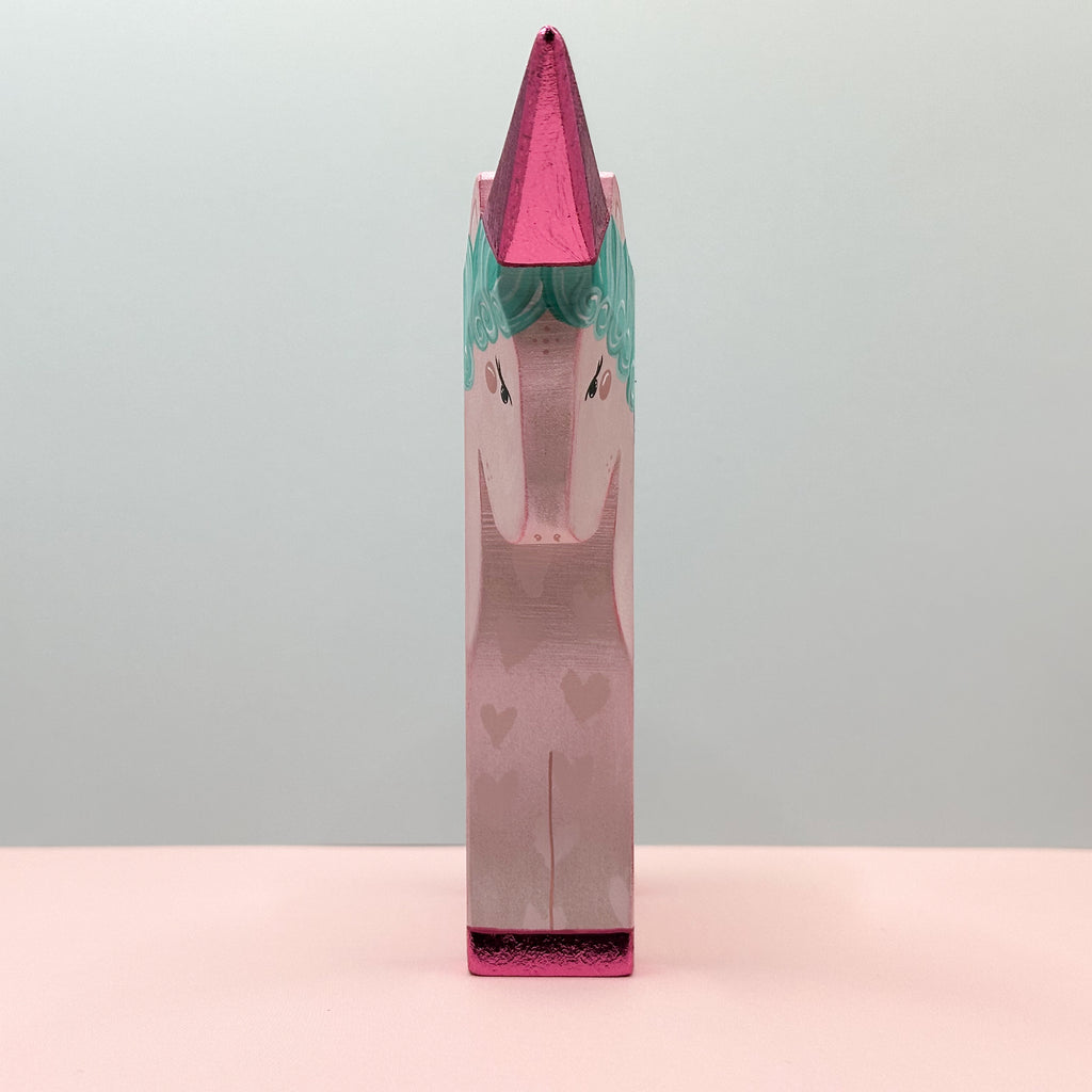 Unicorn-shaped product with pink and green design on a gray background