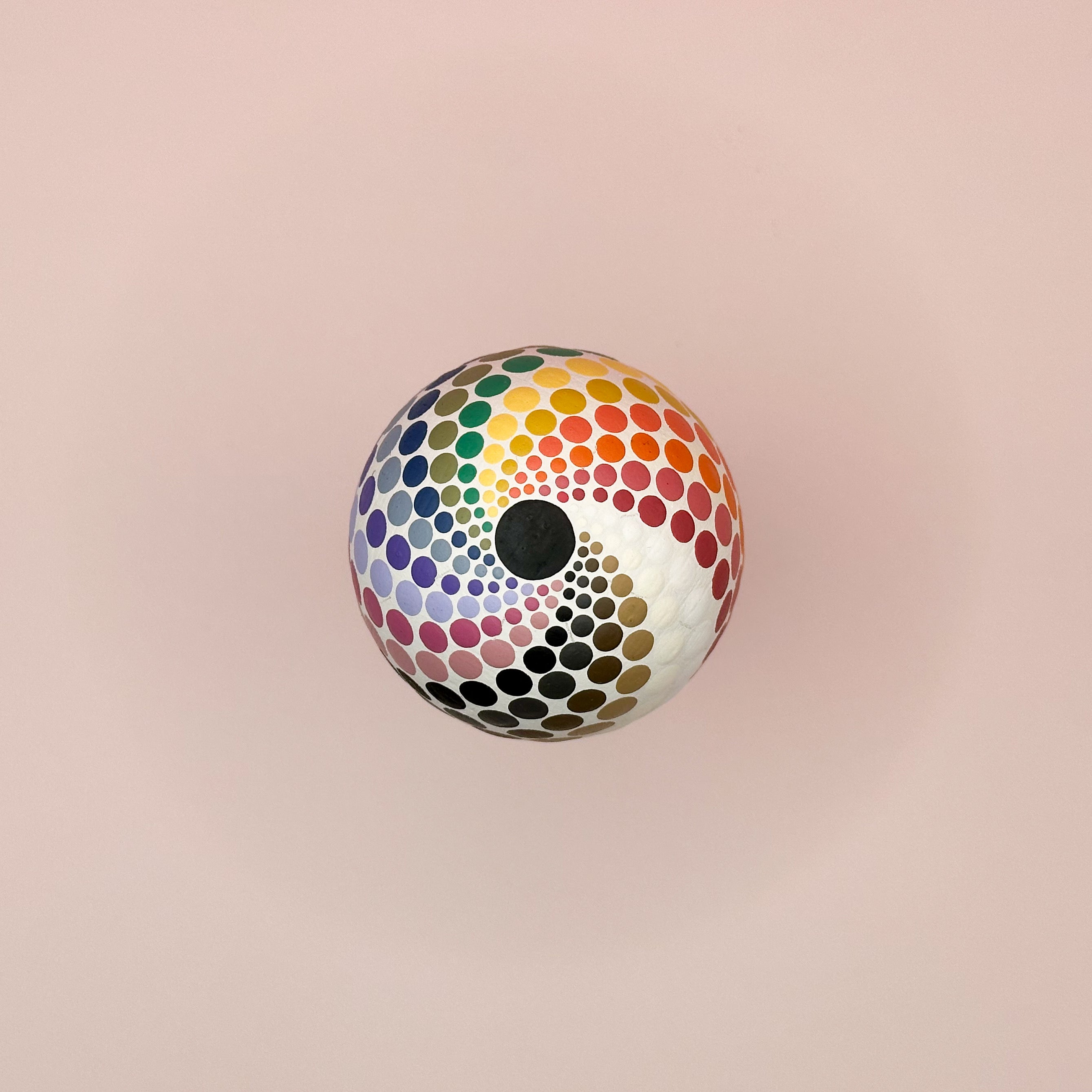 Colorful polka dot ball on a pink background
