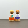 Two wooden peg dolls wearing sun safe swimwear