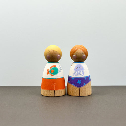Two wooden peg dolls wearing sun safe swimwear
