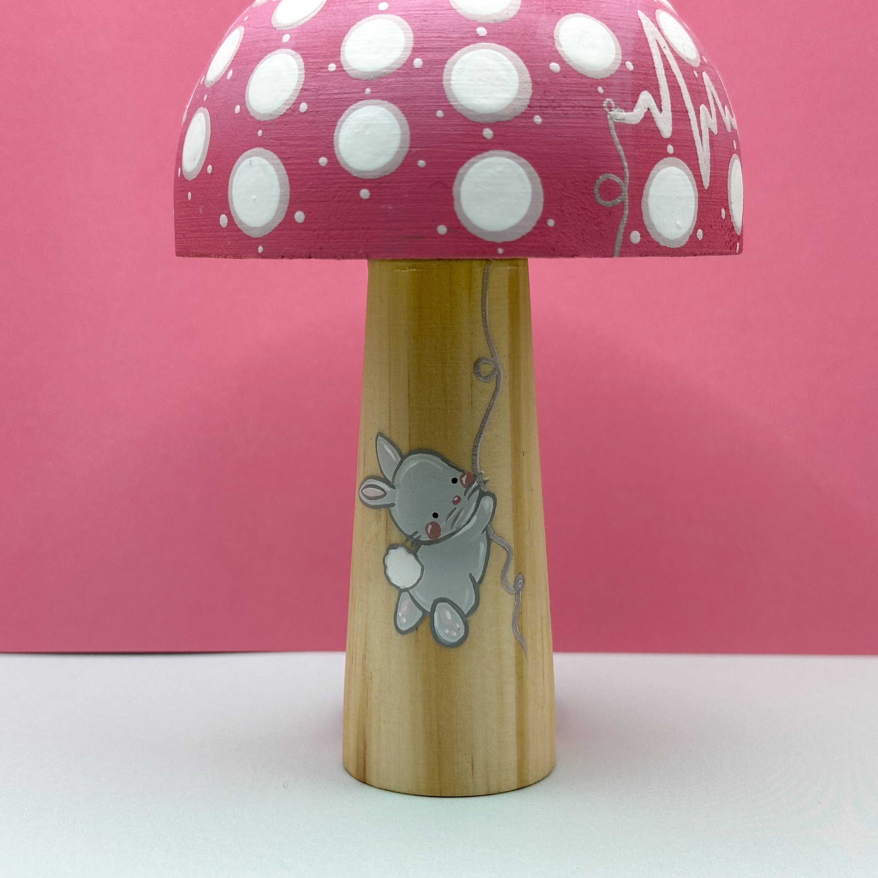 Mushroom-shaped toy with polka dot shade and rabbit design on a pink background