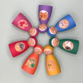 Colorful wooden peg dolls with painted tummies representing various feelings arranged in a circle on a light gray background