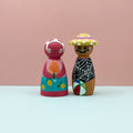 Two colorful wooden peg dolls on a light pink background