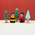 Set of colorful wooden figurines with trees against a red background