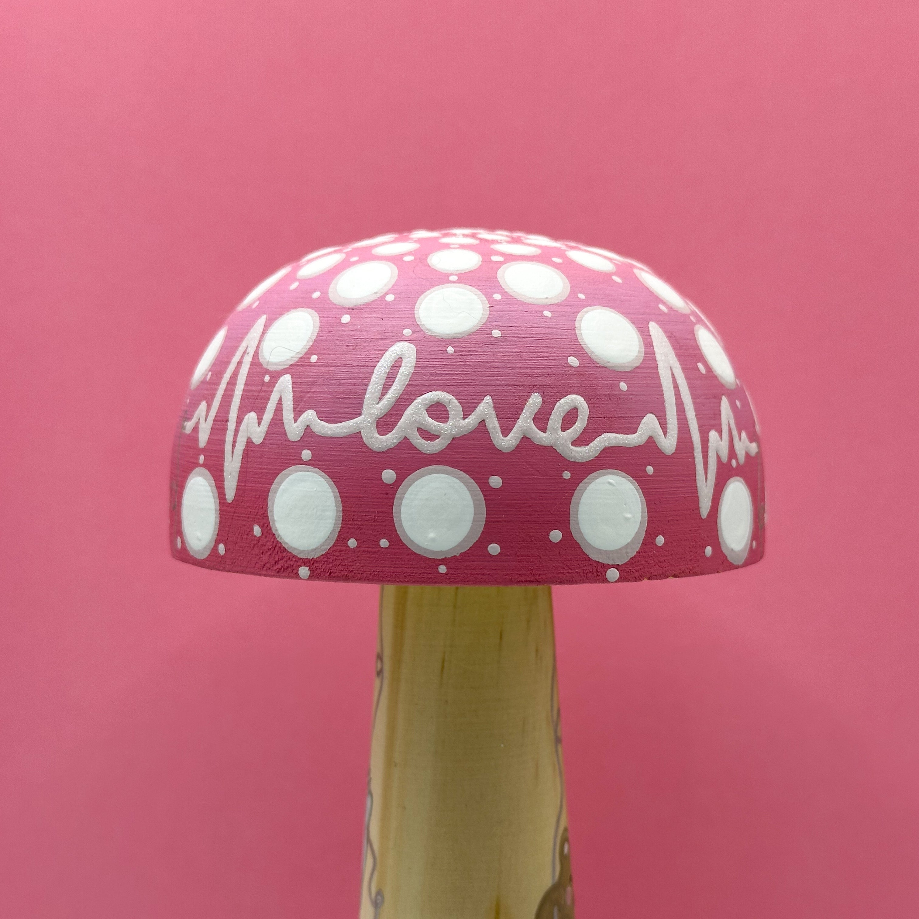 Mushroom-shaped object with 'love' text on a pink background