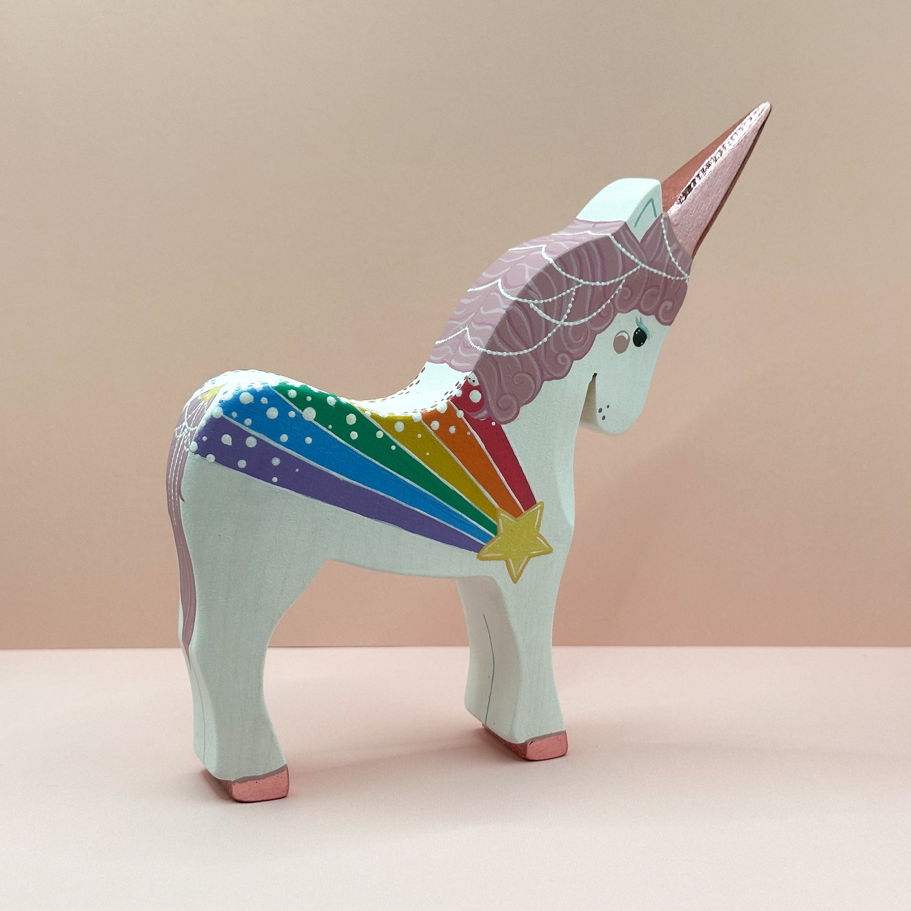 Colorful unicorn figurine with rainbow pattern on a beige background