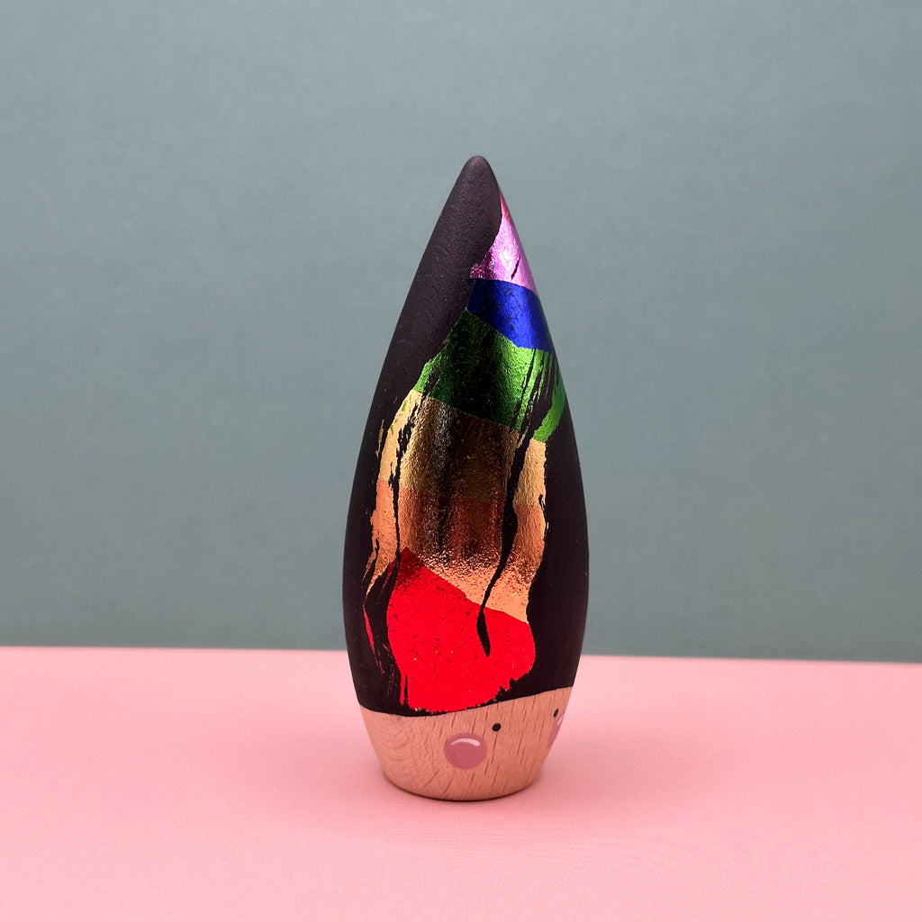 Decorative item with colorful design on a pink surface and gray background