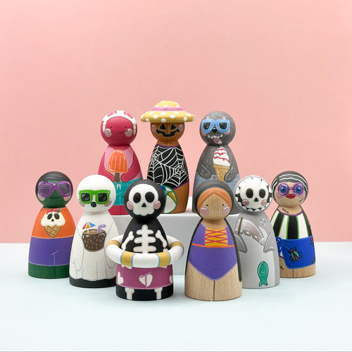 Set of colorful wooden peg dolls with unique designs on a pink background