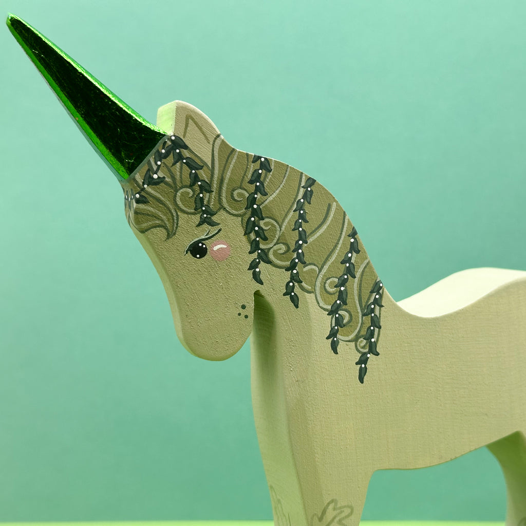 Unicorn figurine with decorative elements on a green background