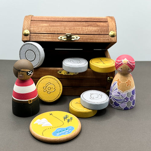 Wooden toy treasure chest with wooden peg dolls, wooden coins and a round disc shaped treasure map