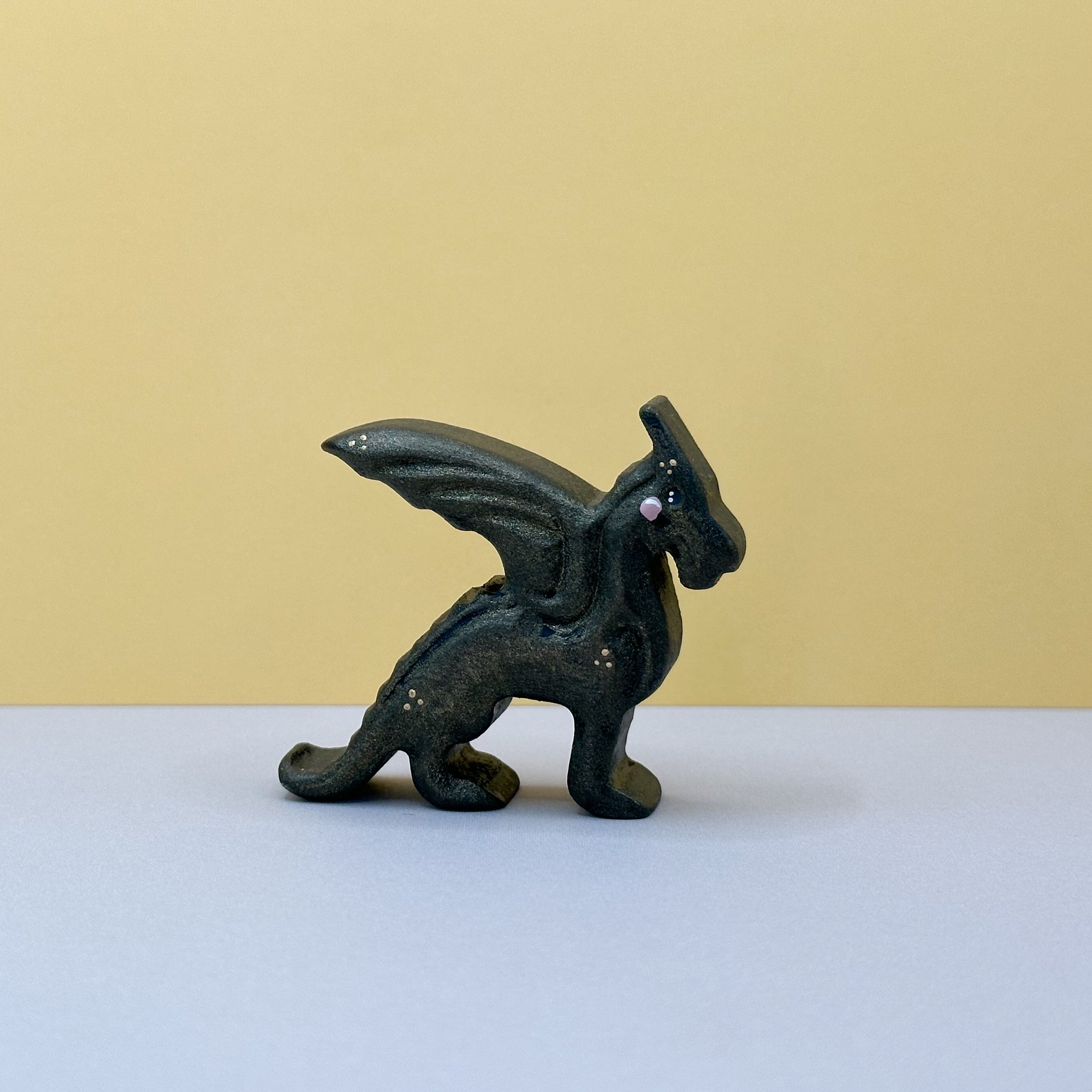 A small wooden black dragon on a yellow background