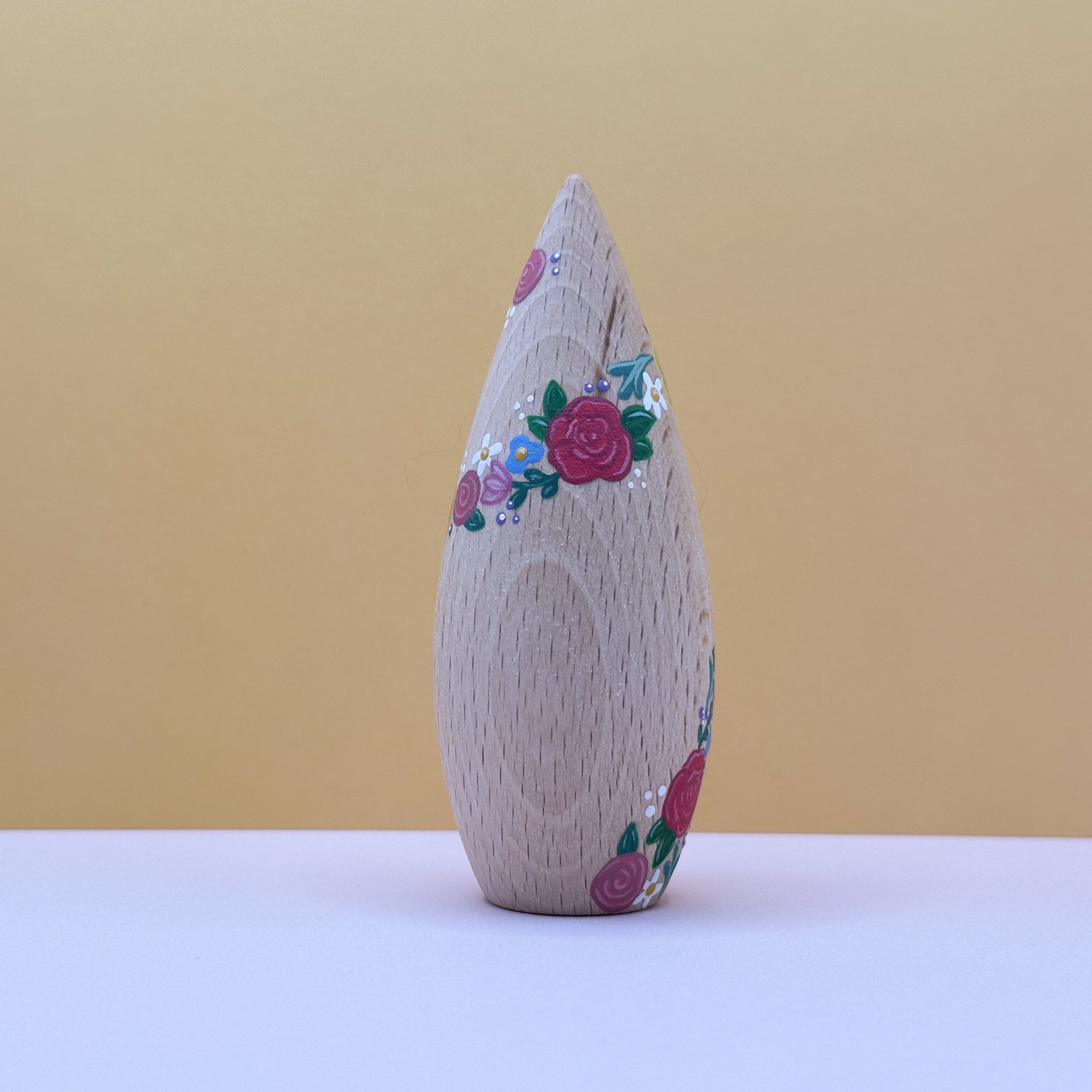 Wooden toy with floral patterns on a beige background