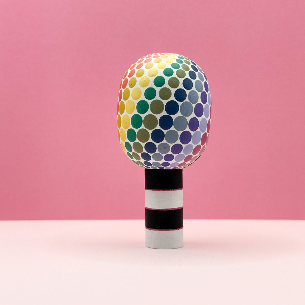 Colorful polka dot object on a pink background