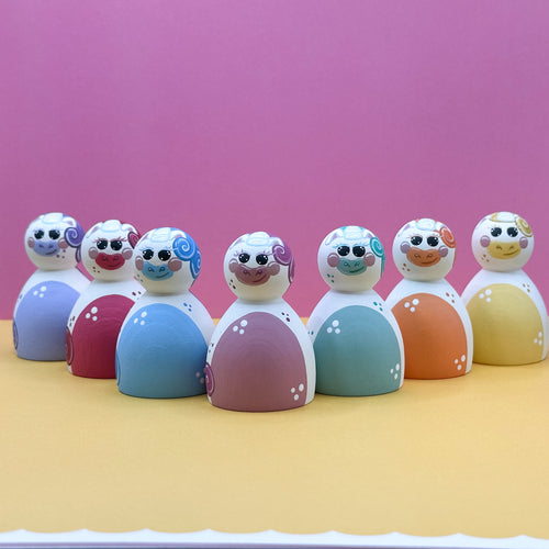 Set of colorful toys with face designs on a pink and yellow background