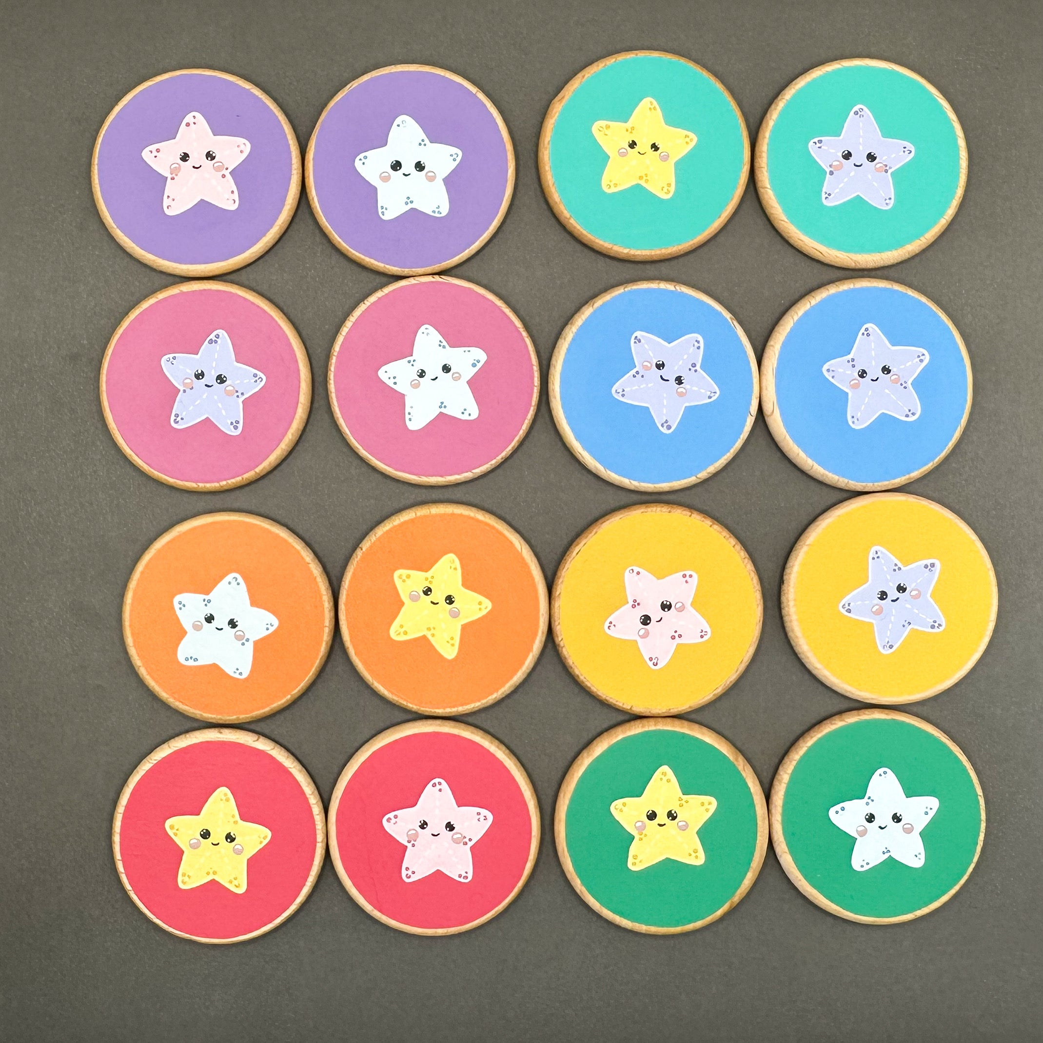 Colourful wooden discs with sea creatures painted on them. On a black surface